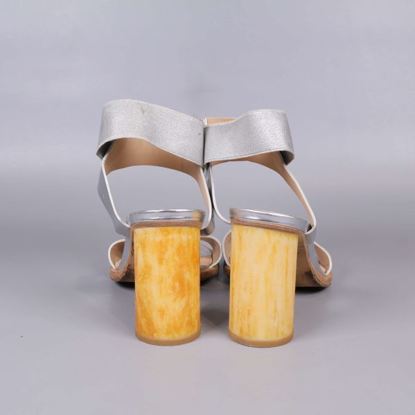 Baksida på sandaler med marmorerad gul klack