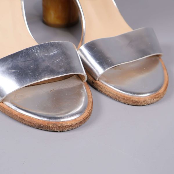 Närbild på tåpartiet av sandaler med silverband