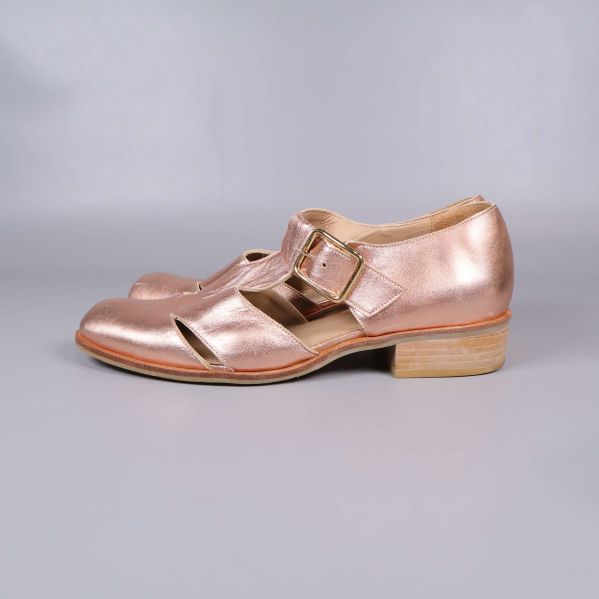 Sida av sandal med dekorativt spänne och träklack