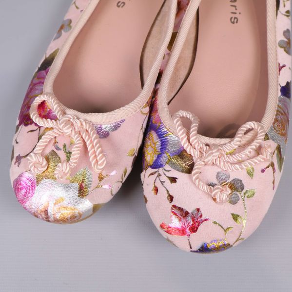 Närbild på tåpartiet av ballerinaskor med dekorativa rosetter och blommönster