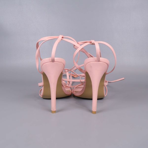 Baksidan av sandaler med rosa snörning och stiletthäl