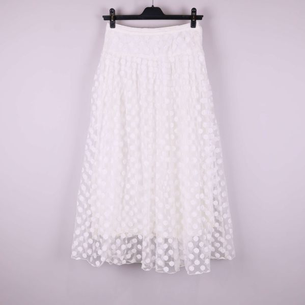 Framsidan av vit kjol med prickigt strukturmönster