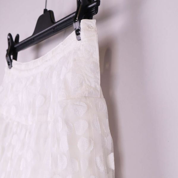 Närbild på midja och sida av vit kjol