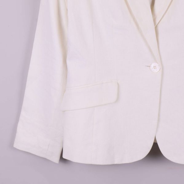 Närbild på ficka och ärm nedtill på vit kavaj