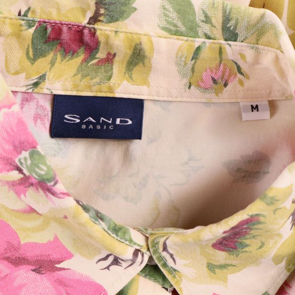 Närbild på skjortkrage och Sand Basic-märke