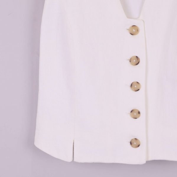 Närbild på nedre delen av västen och knapprad