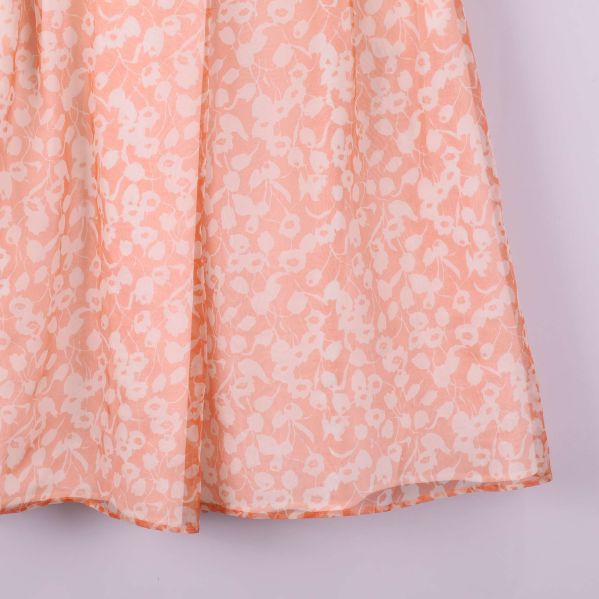 Närbild på kjolens nederkant och blommigt mönster