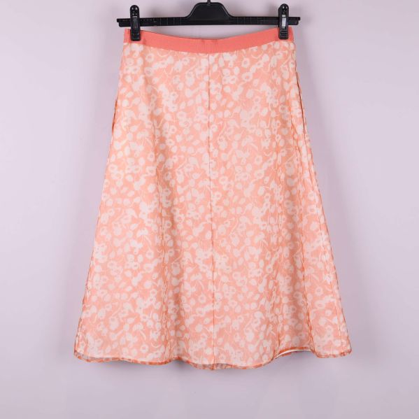 Kjol med aprikosblommor bakifrån mot ljus bakgrund