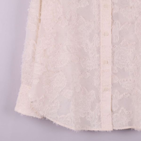 Närbild på skjortans nederkant och knappslå