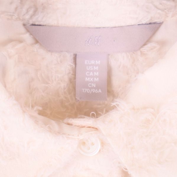 Storleksetikett i nacken på beige skjorta