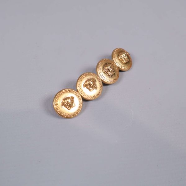 Hårspänne i guld med dekorerade emblem framifrån