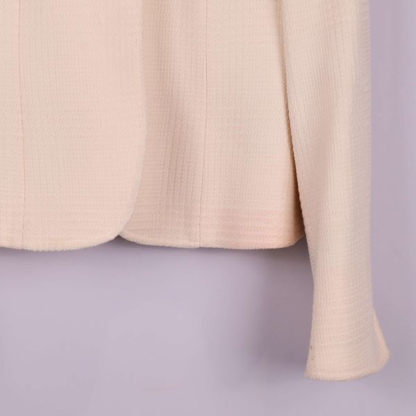 Detaljbild på nederdelen av kavajärm och framsida