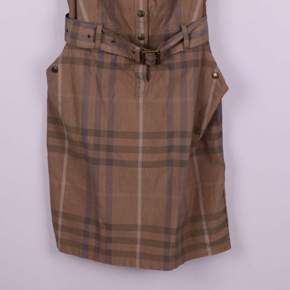 Närbild på fickor och bälte i rutmönstrat tyg