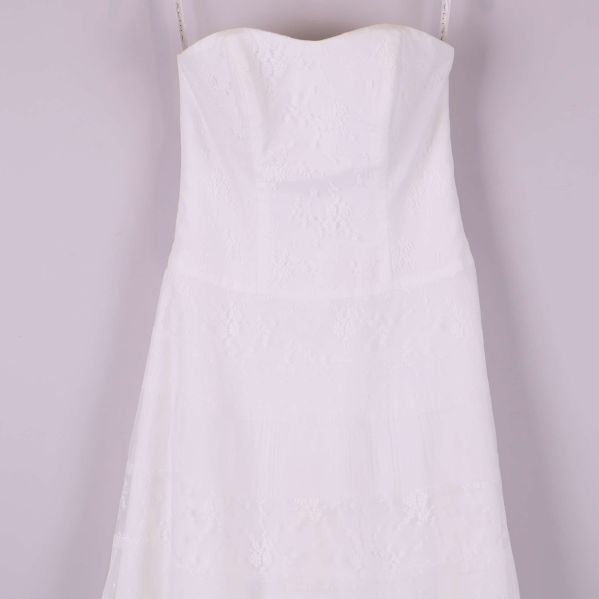 Ovandelen av vit axelbandslös spetsklänning