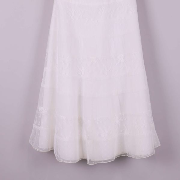 Nederdel av vit klänning med spetsmönster