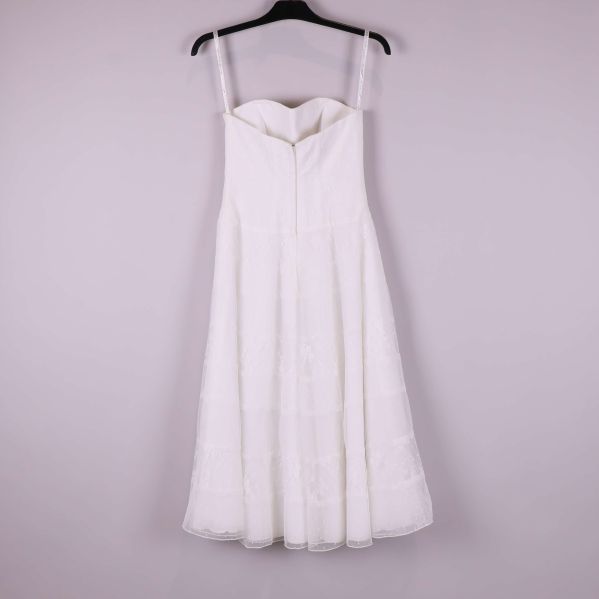 Baksida av vit axelbandslös klänning med dragkedja