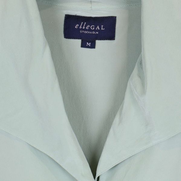 Närbild på etikett från ellegal Stockholm på skjortan