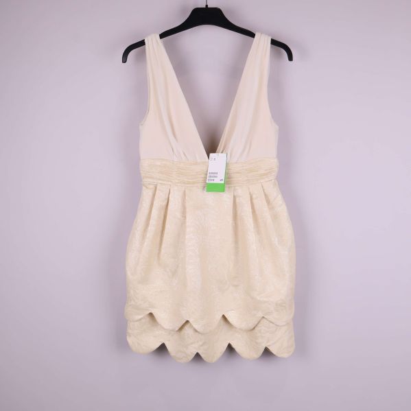 Elegant ljus klänning med djup v-ringning och scallop-kant