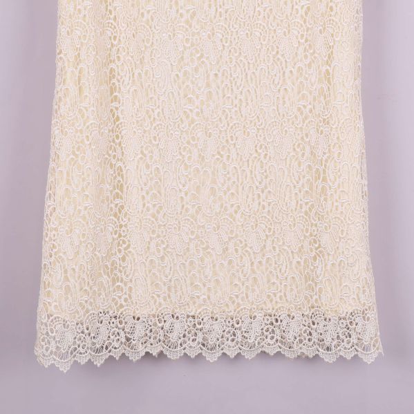 Närbild på klänningens nederkant med spetskant