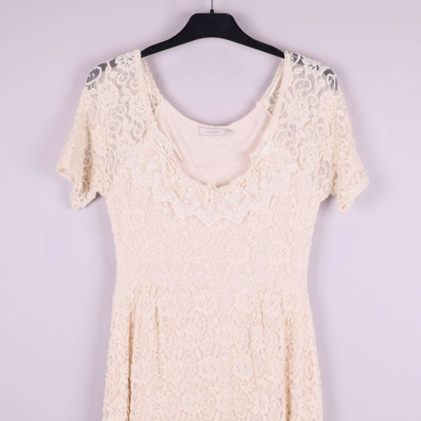 Övre delen av naturvit spetsklänning med rundad hals