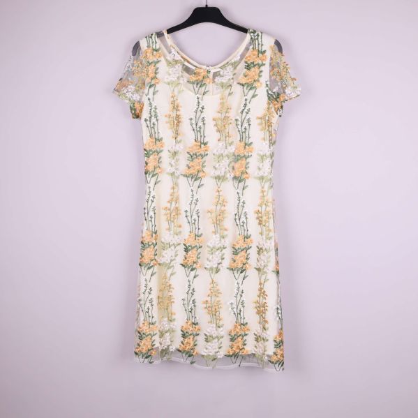 Helbild av ärmlös klänning med blommiga broderier framifrån