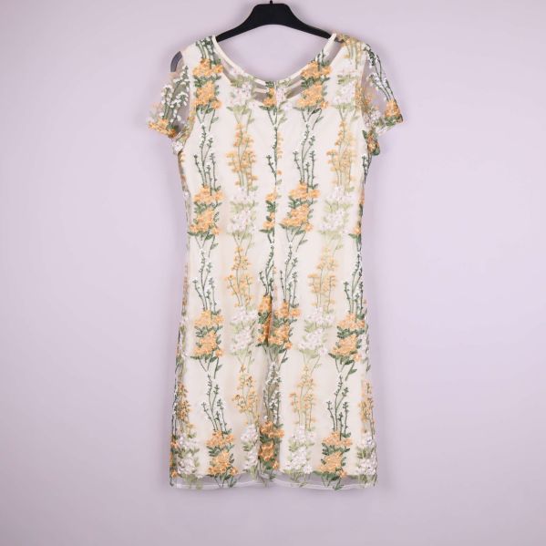 Helbild av ärmlös klänning med blommiga broderier framifrån