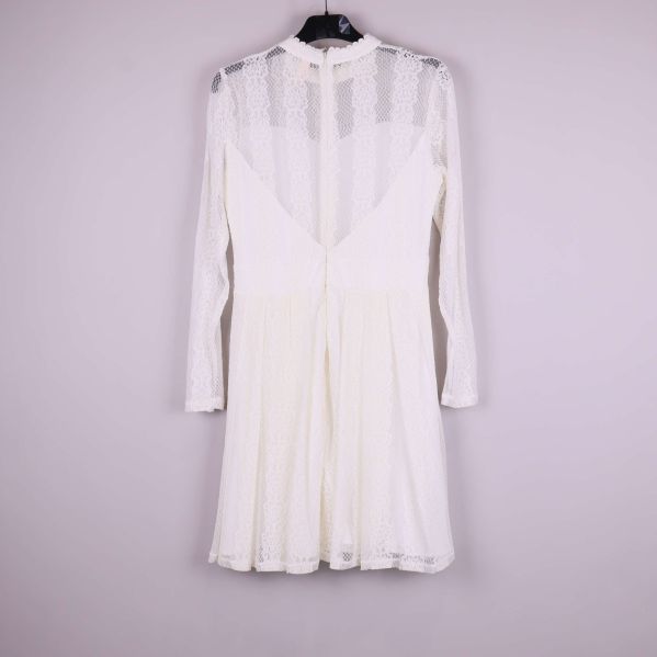 Vit spetsklänning fotad bakifrån med synlig dragkedja