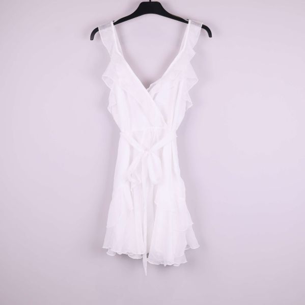 Vit omlottklänning med volanger på galge framsida