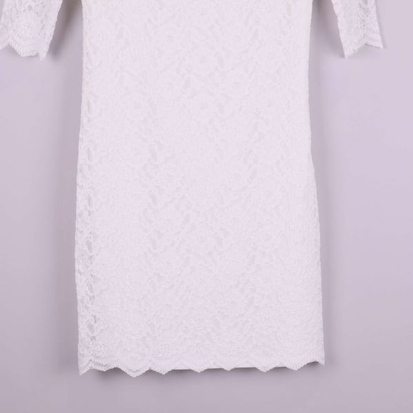 Närbild på klänningens nederdel med vågad spetskant