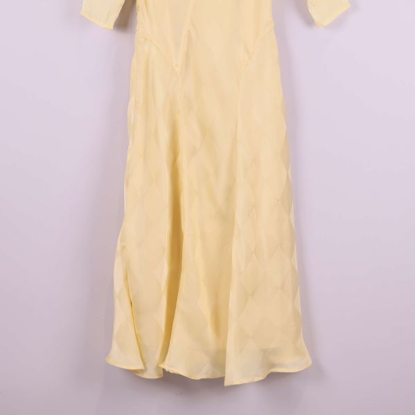 Kjoldel på lång gul klänning med rutstruktur i tyget