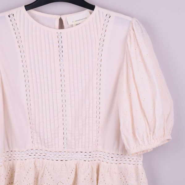 Närbild på blusens framsida med spets och veck