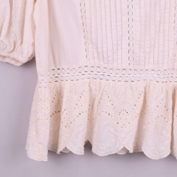 Närbild på nedre delen med broderad spets