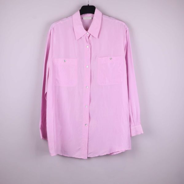 Rosa silkesskjorta med två bröstfickor hängande på galge