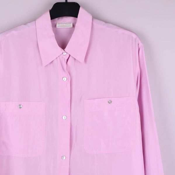 Detaljbild på skjortans bröstfickor och knappar framtill