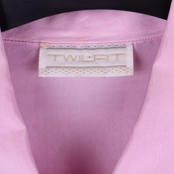 Närbild på vit etikett med texten TWILFIT i kragen