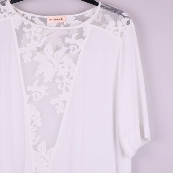 Detaljbild på axel och ärm med spetsmönster