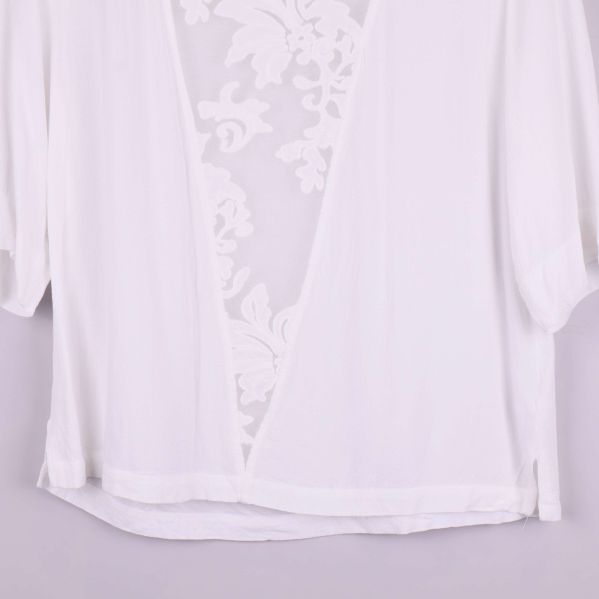 Närbild på nederdel av vit topp