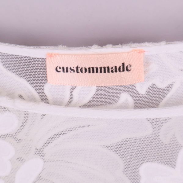 Närbild på rosa etikett med texten custommade