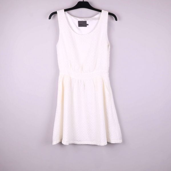 Ärmlös vit klänning med struktur på galge