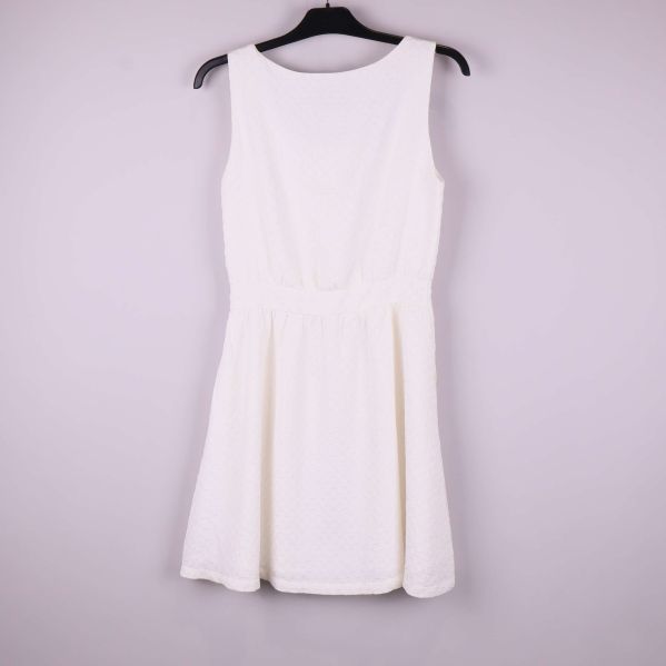 Baksidan av vit ärmlös klänning med struktur