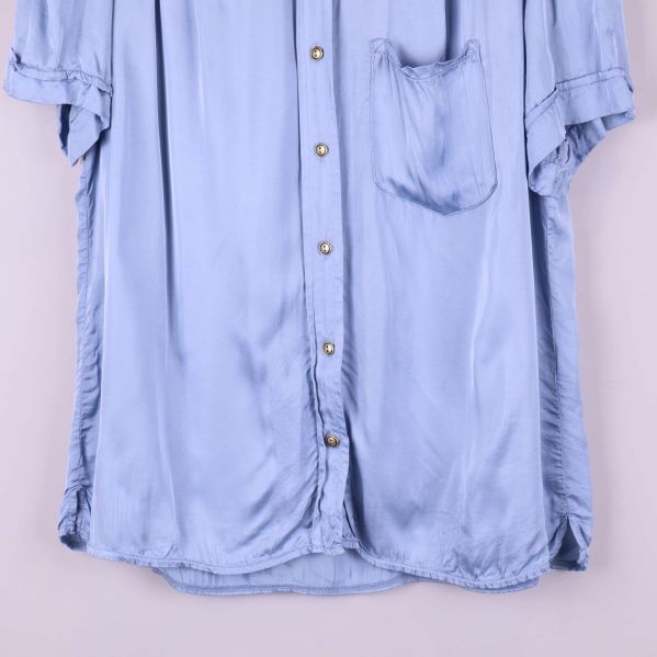 Närbild på nederdelen av blusens framsida med knappar