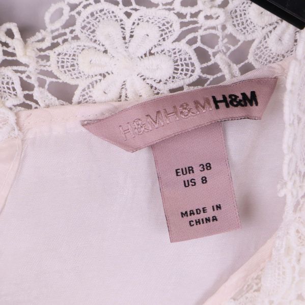 Närbild på H&M etikett och storlekslapp upptill i klänning