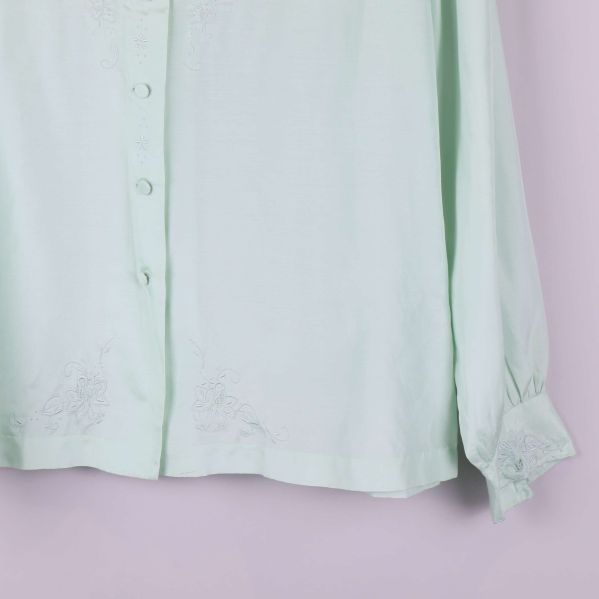 Närbild på nedre del av blusen och manschett