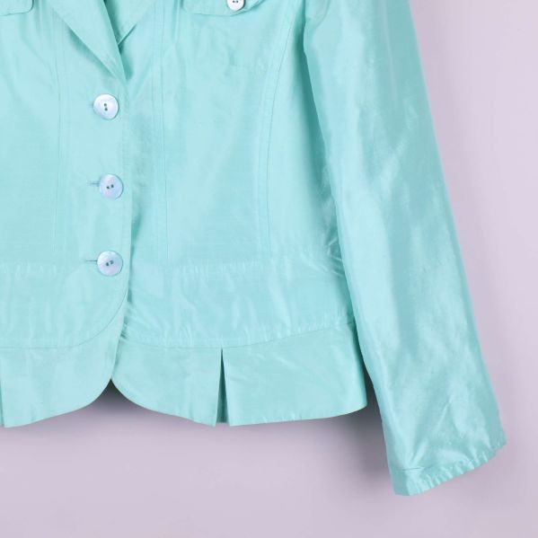 Närbild nedre del av blazer med knappar och fickdetalj