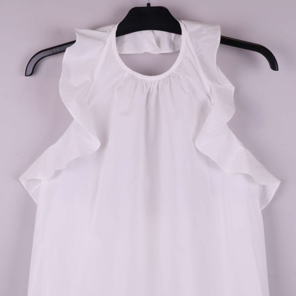 Detaljbild på hals och volanger av blus