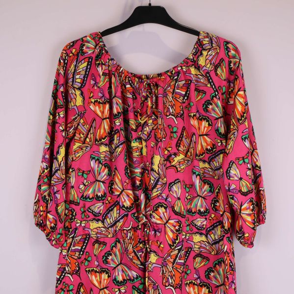 Närbild av halsringning och ärm med fjärilsmönster