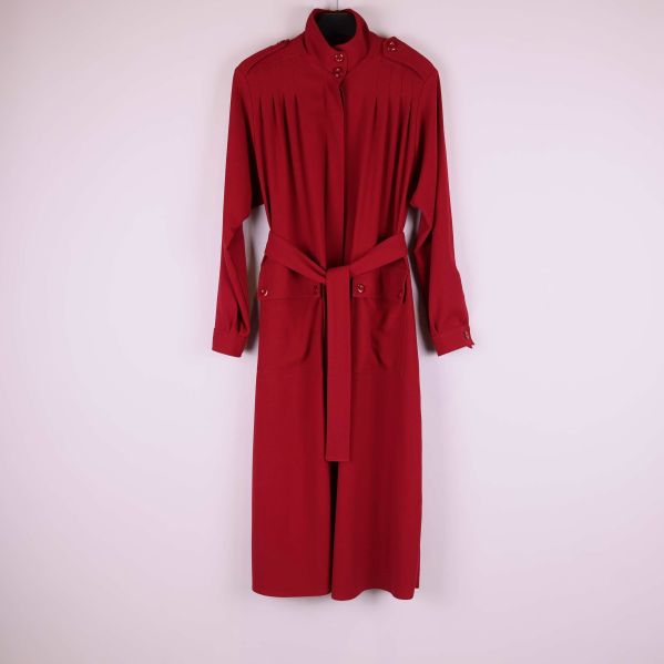 Lång röd kappa på galge mot ljus bakgrund