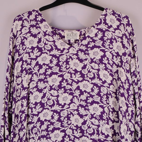 Närbild på blusens blommiga mönster och halsringning