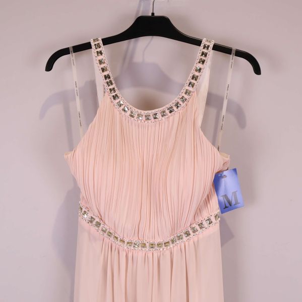 Närbild framtill på plisserad överdel och strassringning