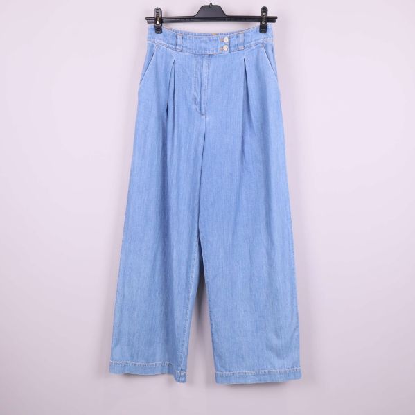 Framsida av vida ljusblå jeans på galge